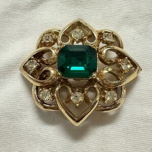 Antique brooch with stones and one big green stone in the Center